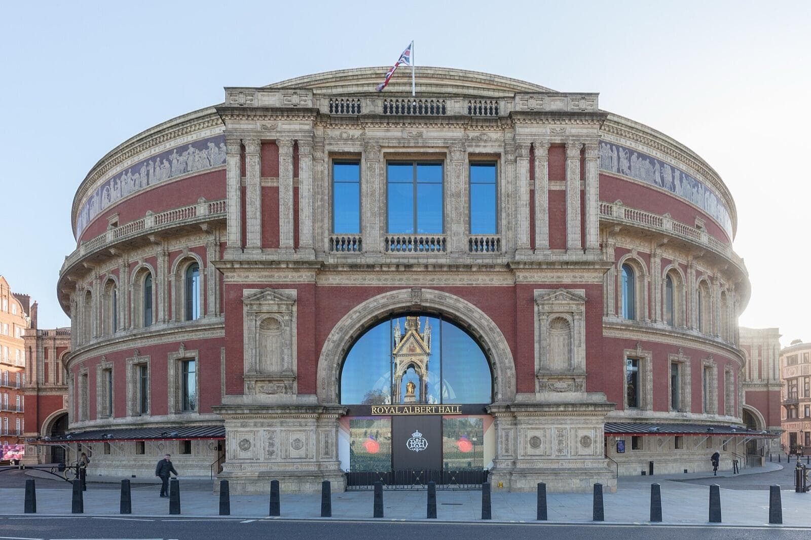 The Royal Albert Hall's north entrance on Kensington Gore, with the Albert Memorial reflected in its glass arch